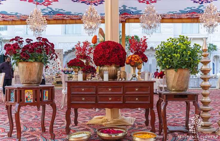 Luxury wedding decor with red florals and chandeliers