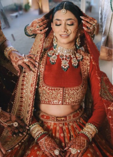 Bride in red lehenga with mehendi hands